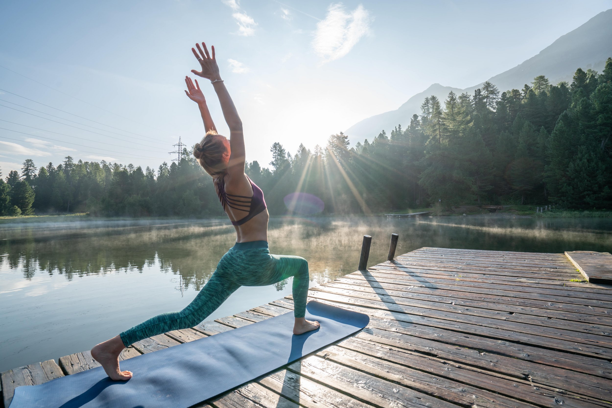 Woman doing a yoga exercise during sunset